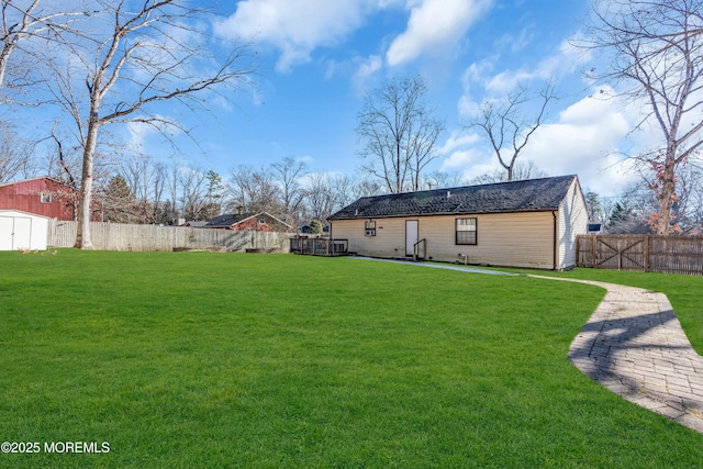 back of house featuring a lawn and a storage shed