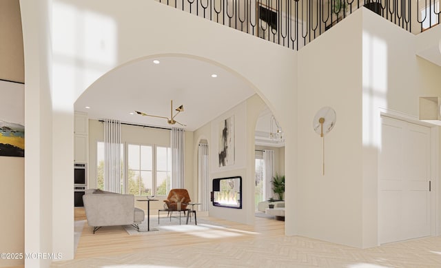 living room featuring a high ceiling, light parquet flooring, and an inviting chandelier