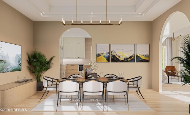 dining room featuring light hardwood / wood-style flooring and a tray ceiling