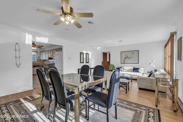 dining room with ceiling fan and light hardwood / wood-style flooring