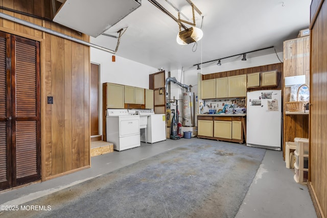 garage with wooden walls, separate washer and dryer, water heater, and white fridge