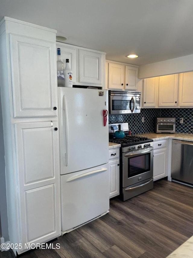 kitchen featuring tasteful backsplash, white cabinetry, dark hardwood / wood-style floors, and appliances with stainless steel finishes