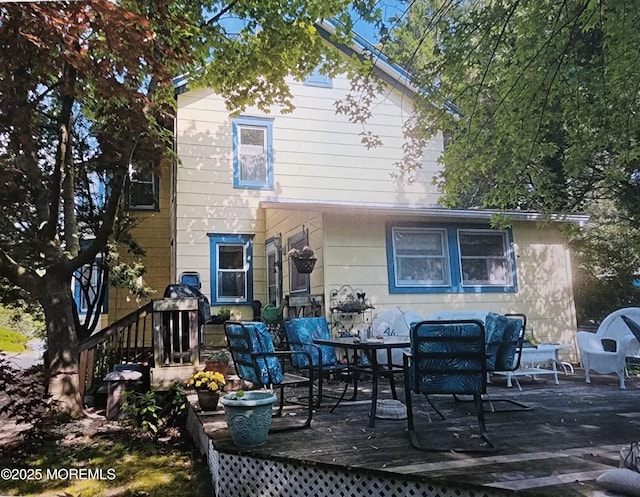 rear view of house featuring a wooden deck