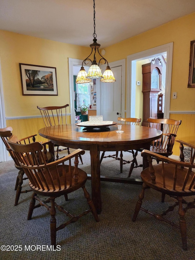 dining room featuring wooden walls and carpet floors