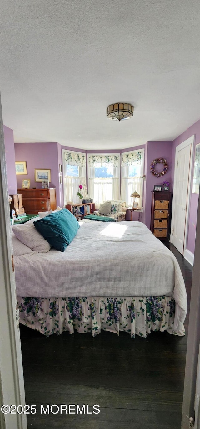 bedroom featuring a textured ceiling and dark wood-type flooring