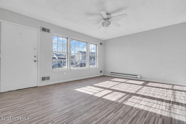 interior space with a textured ceiling, ceiling fan, a baseboard radiator, and light hardwood / wood-style flooring