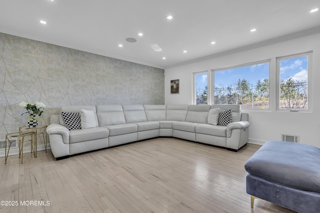 living room featuring crown molding and light hardwood / wood-style flooring