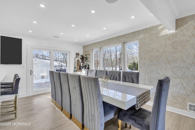 dining space with beamed ceiling, light hardwood / wood-style floors, and ornamental molding