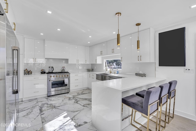 kitchen with kitchen peninsula, pendant lighting, white cabinetry, and high quality appliances