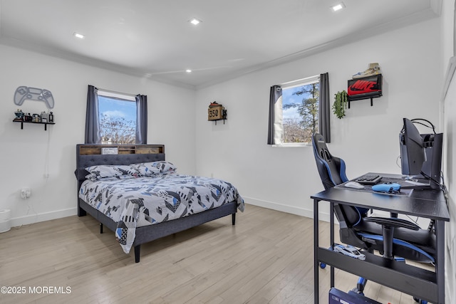 bedroom featuring crown molding and light hardwood / wood-style flooring