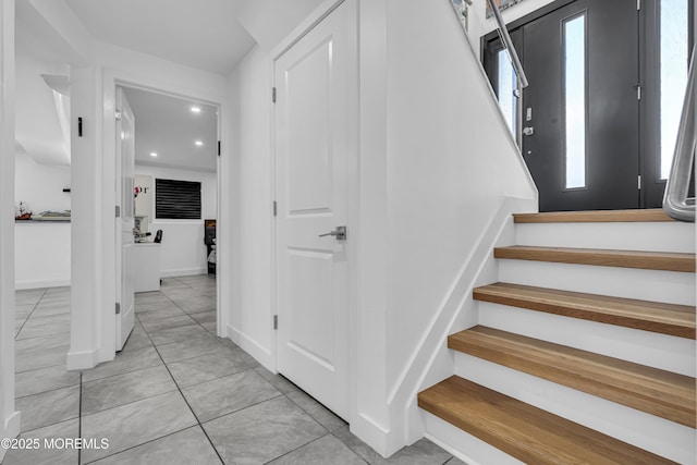 stairway featuring tile patterned floors and a healthy amount of sunlight