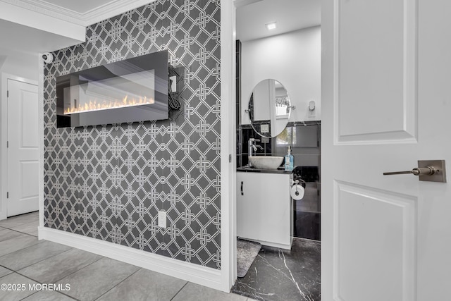 bathroom with vanity, a large fireplace, and crown molding