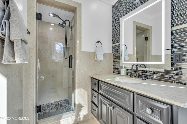 bathroom featuring tasteful backsplash, a shower with door, and vanity