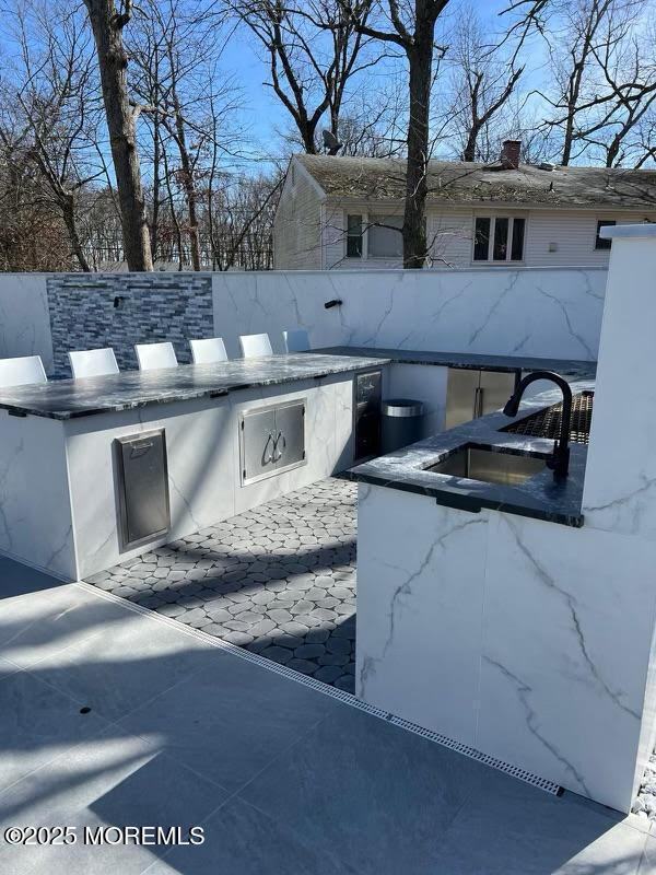 view of patio featuring an outdoor kitchen and sink