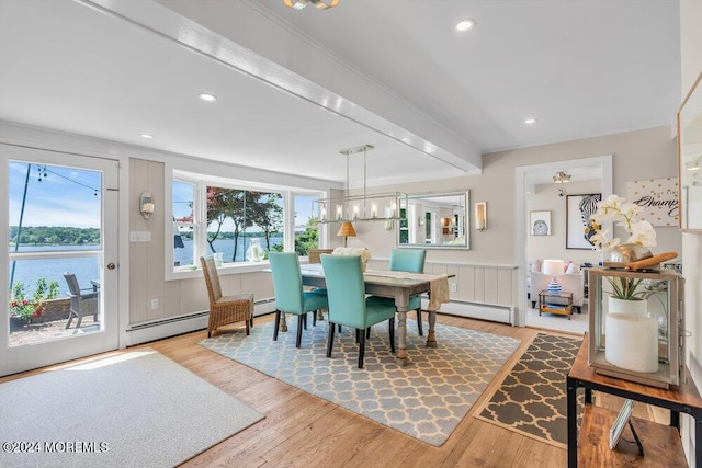 dining area featuring hardwood / wood-style floors, a water view, and a baseboard radiator