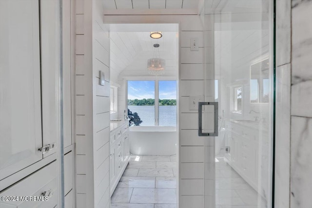 bathroom with sink, a water view, and independent shower and bath