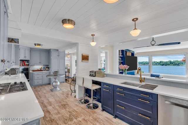 kitchen featuring dishwasher, hanging light fixtures, wood ceiling, blue cabinets, and sink