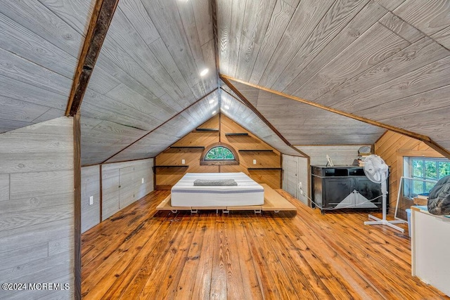 unfurnished bedroom with wood walls, vaulted ceiling, wood ceiling, and hardwood / wood-style floors