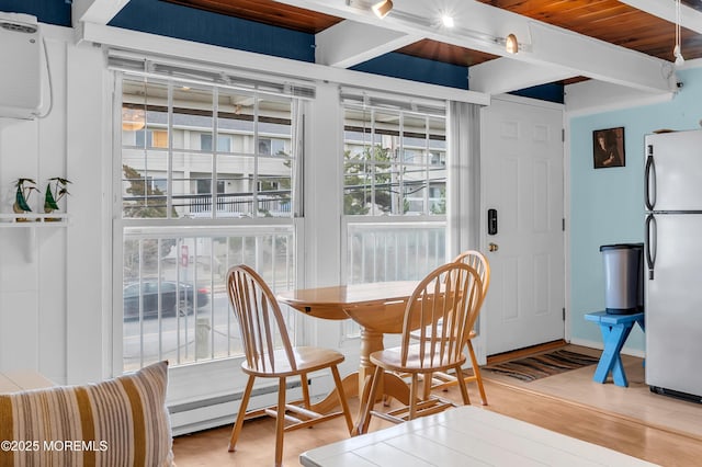 dining room featuring wood ceiling, hardwood / wood-style floors, a baseboard radiator, and beamed ceiling