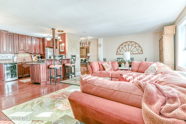 living room with light wood-type flooring and beverage cooler