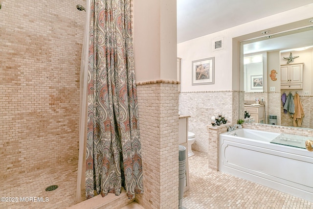 bathroom featuring tile patterned flooring, separate shower and tub, toilet, and tile walls