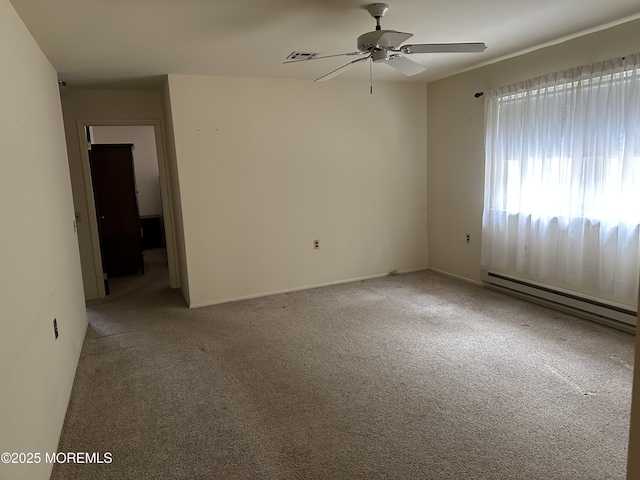 carpeted spare room featuring baseboard heating and ceiling fan