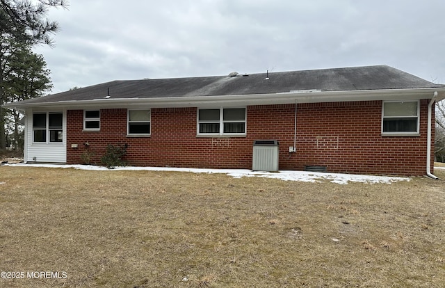 back of house with central AC and a yard