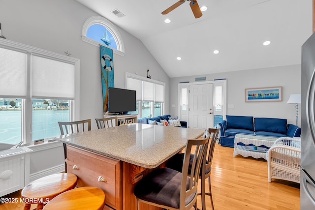 kitchen featuring light hardwood / wood-style floors, high vaulted ceiling, ceiling fan, and a wealth of natural light