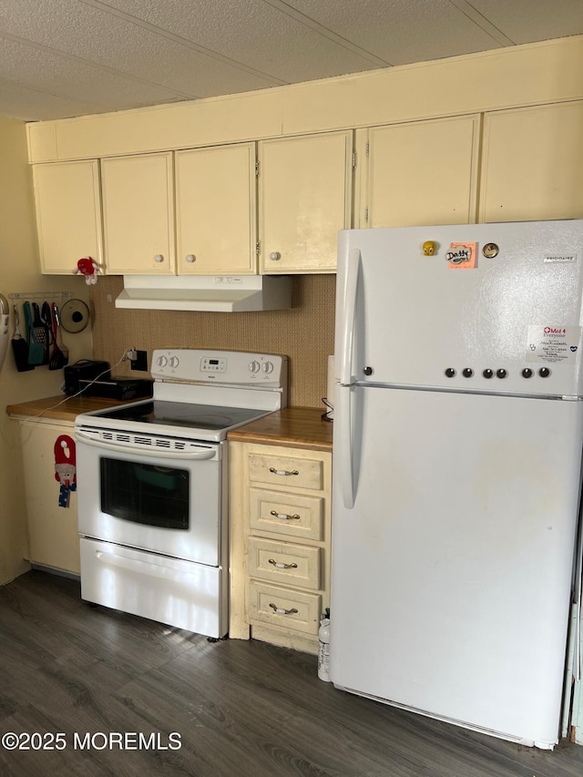 kitchen featuring cream cabinets, dark wood-type flooring, and white appliances