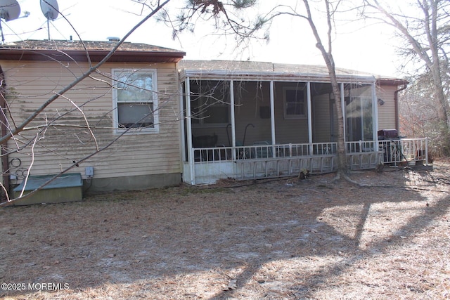 rear view of house featuring a sunroom