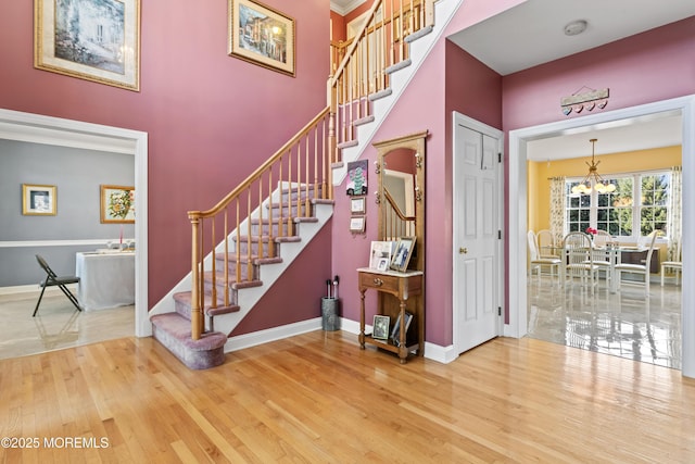 stairs with a chandelier and hardwood / wood-style floors