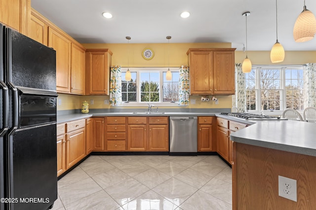 kitchen featuring sink, plenty of natural light, hanging light fixtures, and appliances with stainless steel finishes