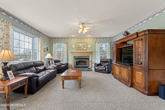 carpeted living room featuring a fireplace and ceiling fan