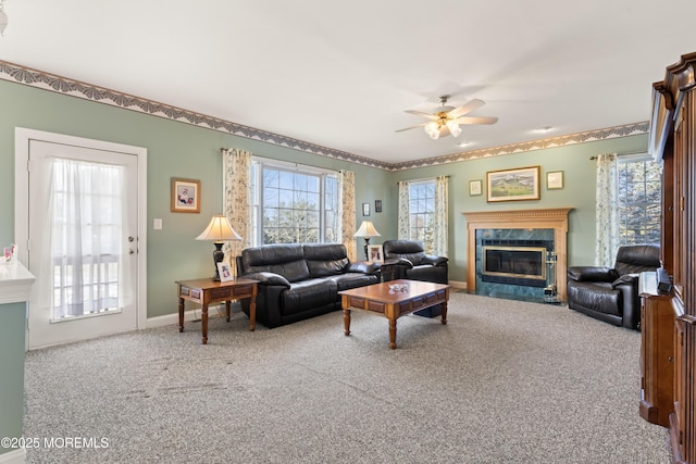 carpeted living room with a premium fireplace and ceiling fan