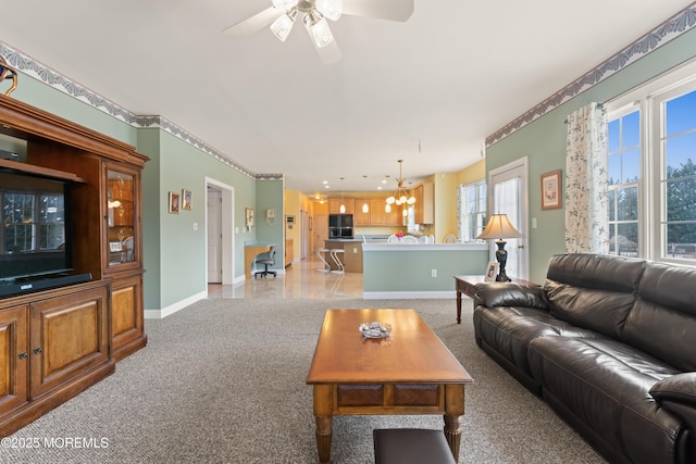 living room featuring ceiling fan with notable chandelier