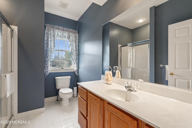 bathroom featuring toilet, a shower with door, vanity, and tile patterned floors