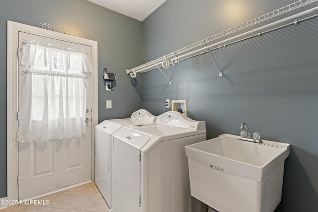 clothes washing area featuring sink, independent washer and dryer, and light tile patterned floors