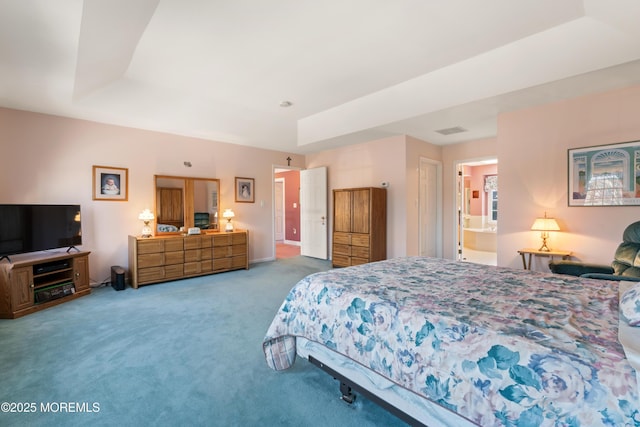 carpeted bedroom featuring connected bathroom and a tray ceiling