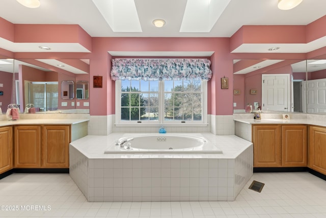 bathroom featuring a skylight, tile patterned floors, independent shower and bath, and vanity