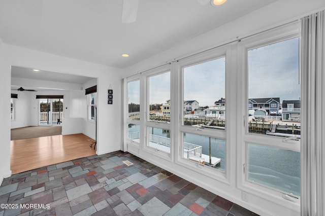 doorway to outside featuring ceiling fan and plenty of natural light