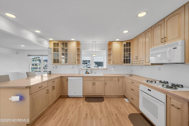 kitchen featuring white appliances, light brown cabinets, and kitchen peninsula