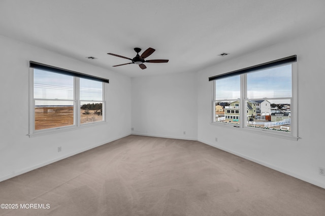 spare room featuring light carpet and ceiling fan