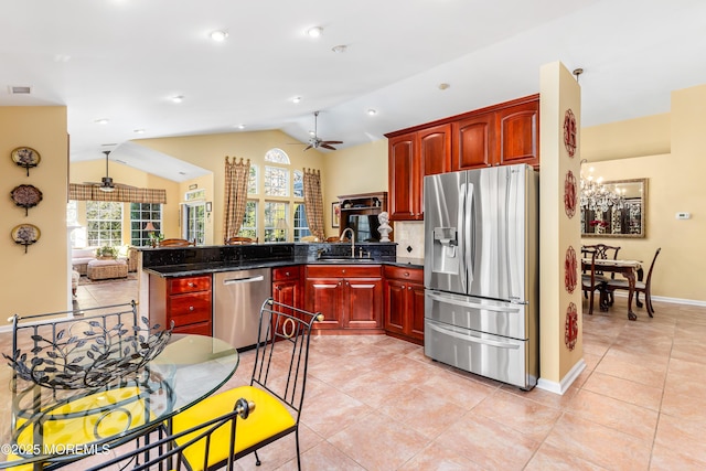 kitchen featuring ceiling fan with notable chandelier, lofted ceiling, stainless steel appliances, sink, and kitchen peninsula