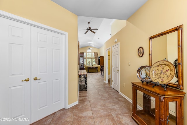 hallway featuring lofted ceiling and light tile patterned flooring