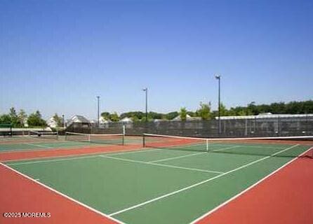 view of tennis court featuring basketball hoop