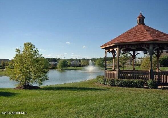 view of dock featuring a water view, a gazebo, and a lawn