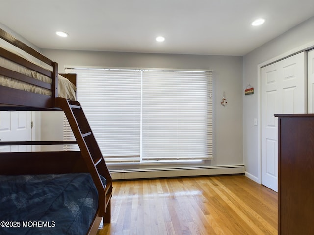 unfurnished bedroom featuring light hardwood / wood-style floors and baseboard heating