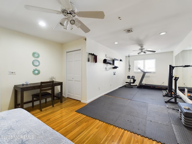 workout room featuring dark wood-type flooring and ceiling fan