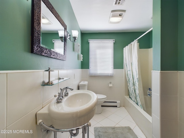 bathroom with tile walls, shower / bath combination with curtain, tile patterned flooring, baseboard heating, and toilet