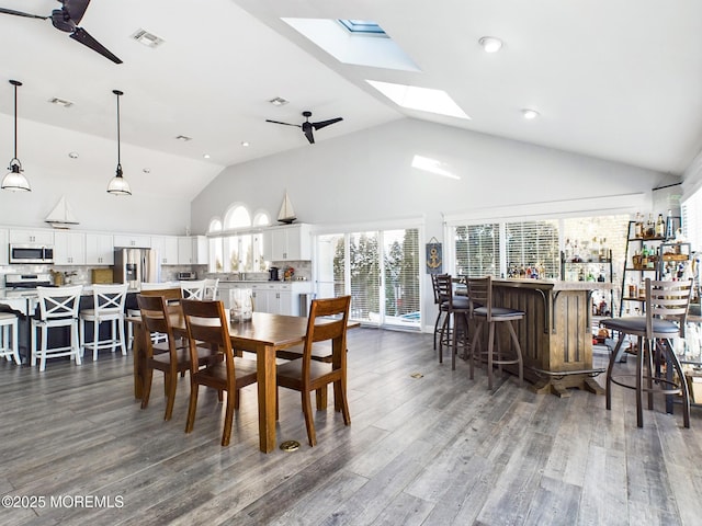 dining room featuring high vaulted ceiling, dark hardwood / wood-style floors, bar area, and ceiling fan